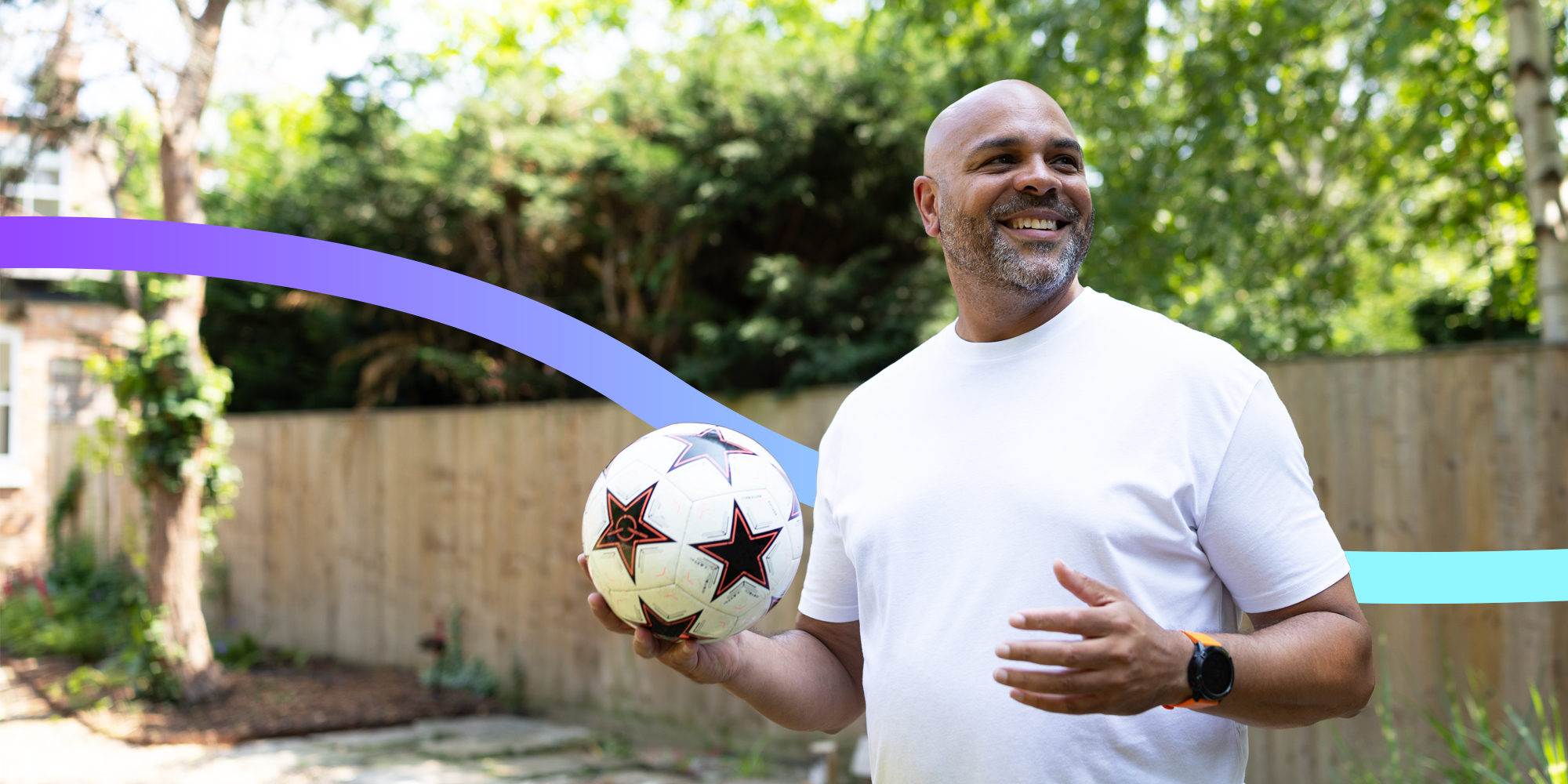 Happy man holding football in the garden.