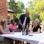 4 people outside around a table with drinks