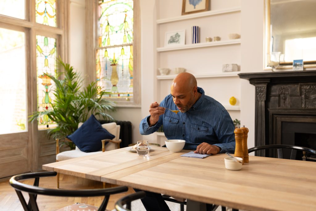 Man eating soup at dining table