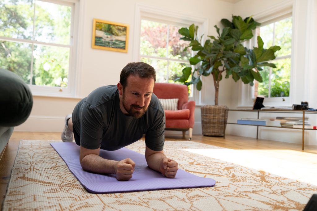 Man working out, planking, in room