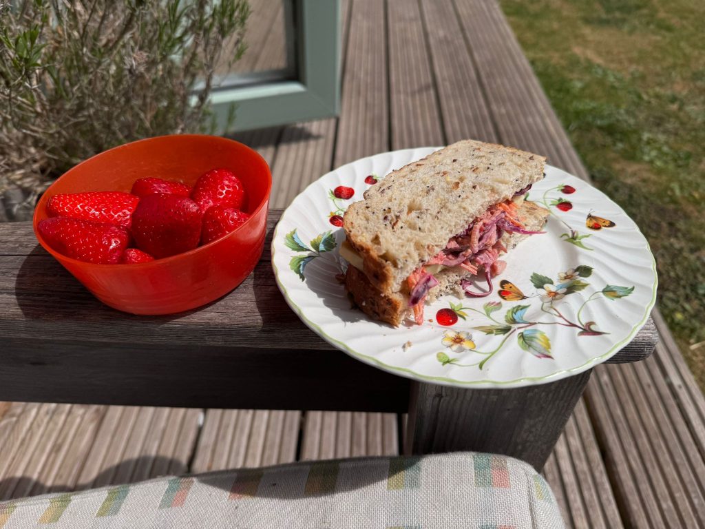 A sandwich and bowl of strawberries