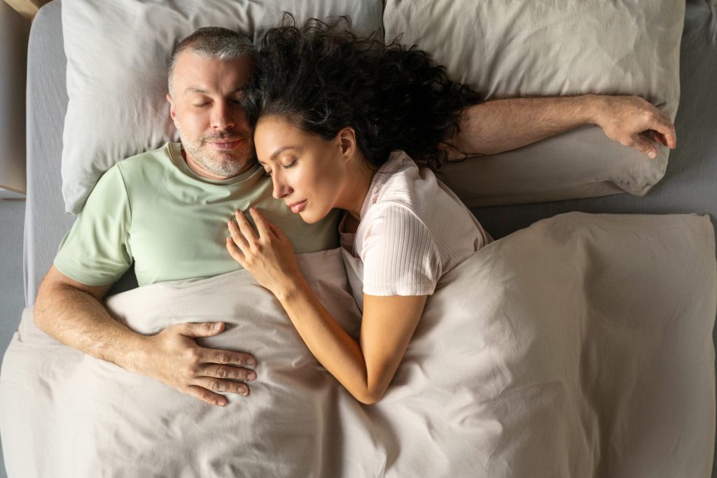 Man in green t-shirt in bed with partner