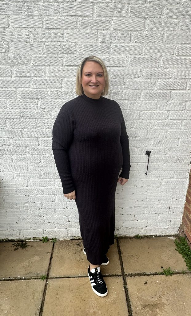 Mel standing against a wall