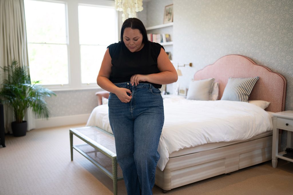 Image showing a lady looking happy zipping up her jeans