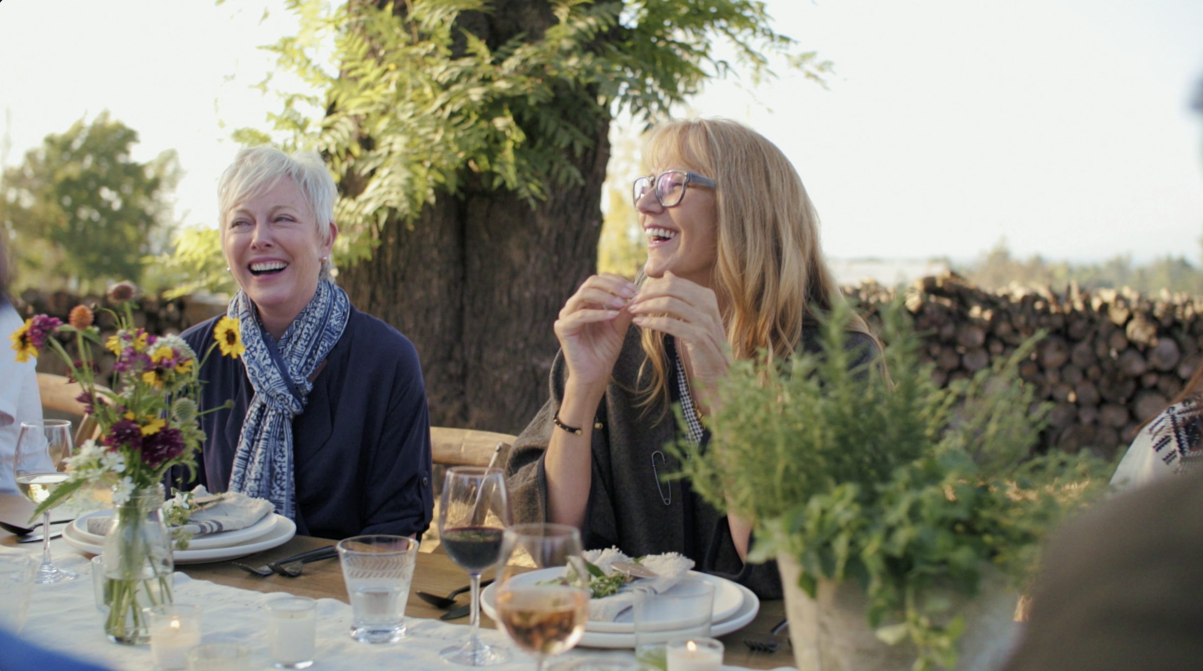 Friends laughing together at an outdoor dinner